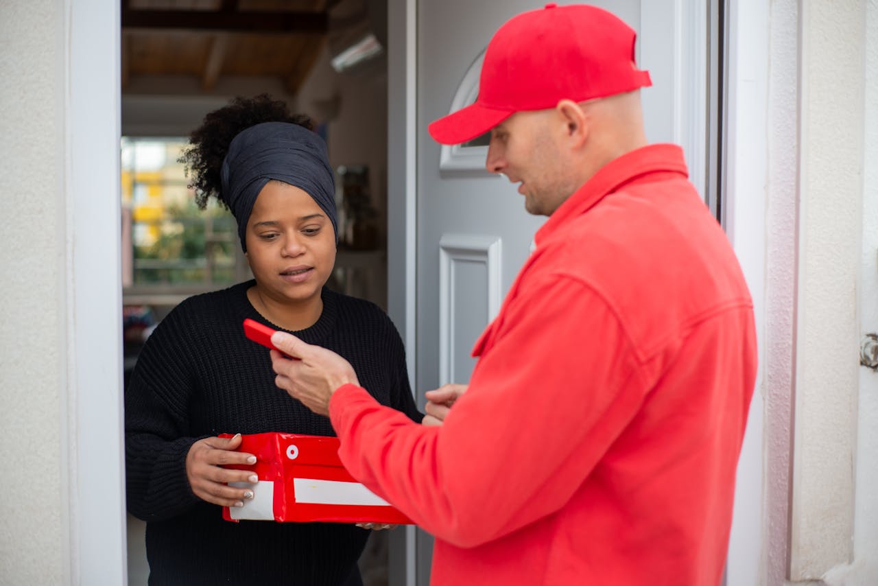 gallery-1 Professional delivery service with a person receiving a red package at their doorstep.